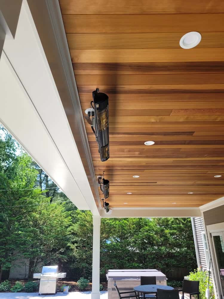 Solaira CosyXL heaters ceiling mounted on beautiful golden brown wooden planks of this residential covered patio
